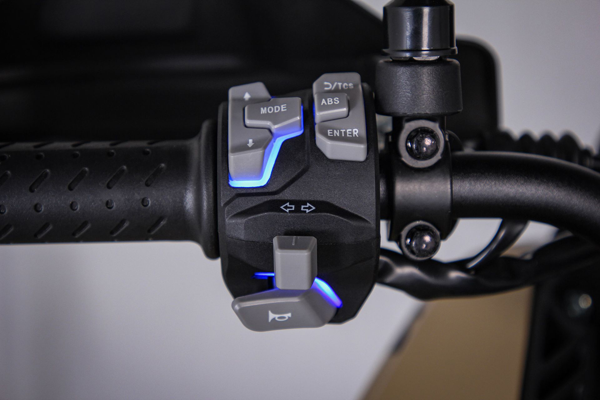 Detalle del puño del manillar con controles modernos y diseño ergonómico.
