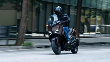 La Yamaha XMAX 2025 muestra su diseño estilizado y aerodinámico en movimiento.