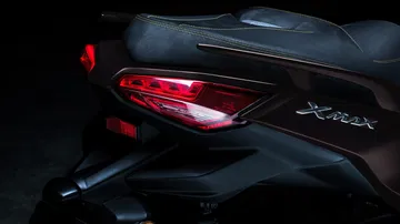 Vista detallada del diseño trasero del Yamaha XMAX 2025, destacando las luces y líneas elegantes.