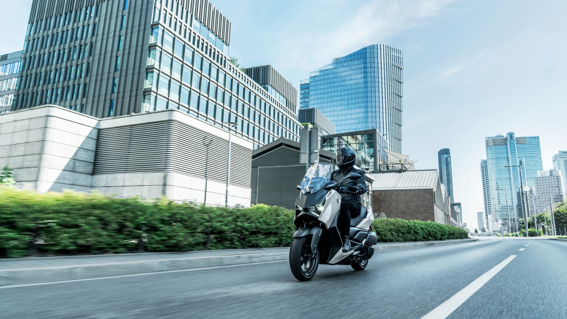 El Yamaha XMAX 2025 muestra su diseño elegante en un entorno urbano moderno.