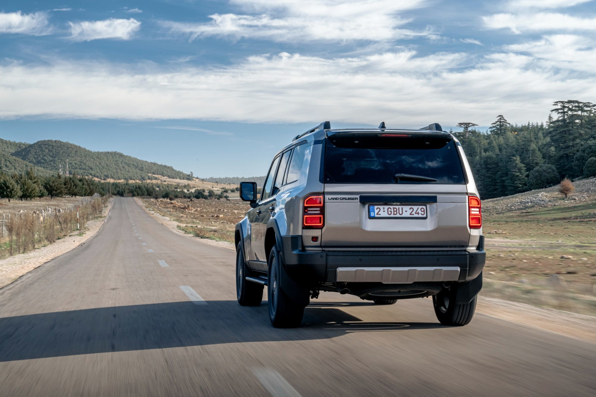 Vista trasera del Toyota Land Cruiser 250 Hybrid 48V en una carretera abierta.