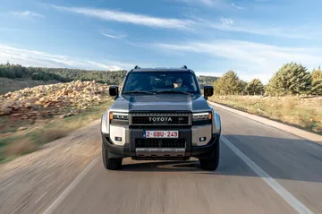 Vista frontal del Toyota Land Cruiser 250 Hybrid, muestra su robustez y diseño audaz. Vista frontal del Toyota Land Cruiser 250 Hybrid, muestra su robustez y diseño audaz.