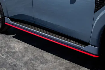 Detalle del estribo lateral del Nissan Armada Nismo 2026, con acentos en rojo.