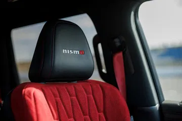 Asiento deportivo con detalles en rojo y emblema Nismo, enfatizando la exclusividad del modelo.