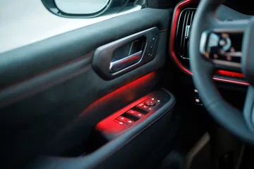 Detalle del interior donde se aprecian los controles de las ventanillas y parte del volante