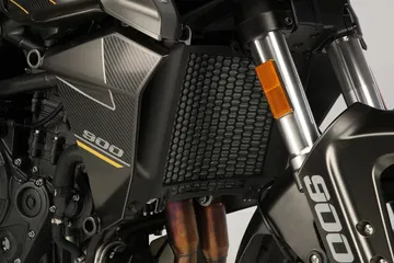 Detalle del radiador en el QJ Motor SRT 900S, mostrando su diseño robusto.