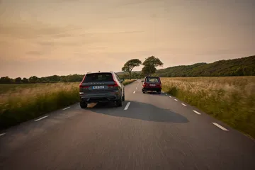 El icónico Volvo 240 se encuentra en armonía con el moderno XC60 en un paisaje rural.