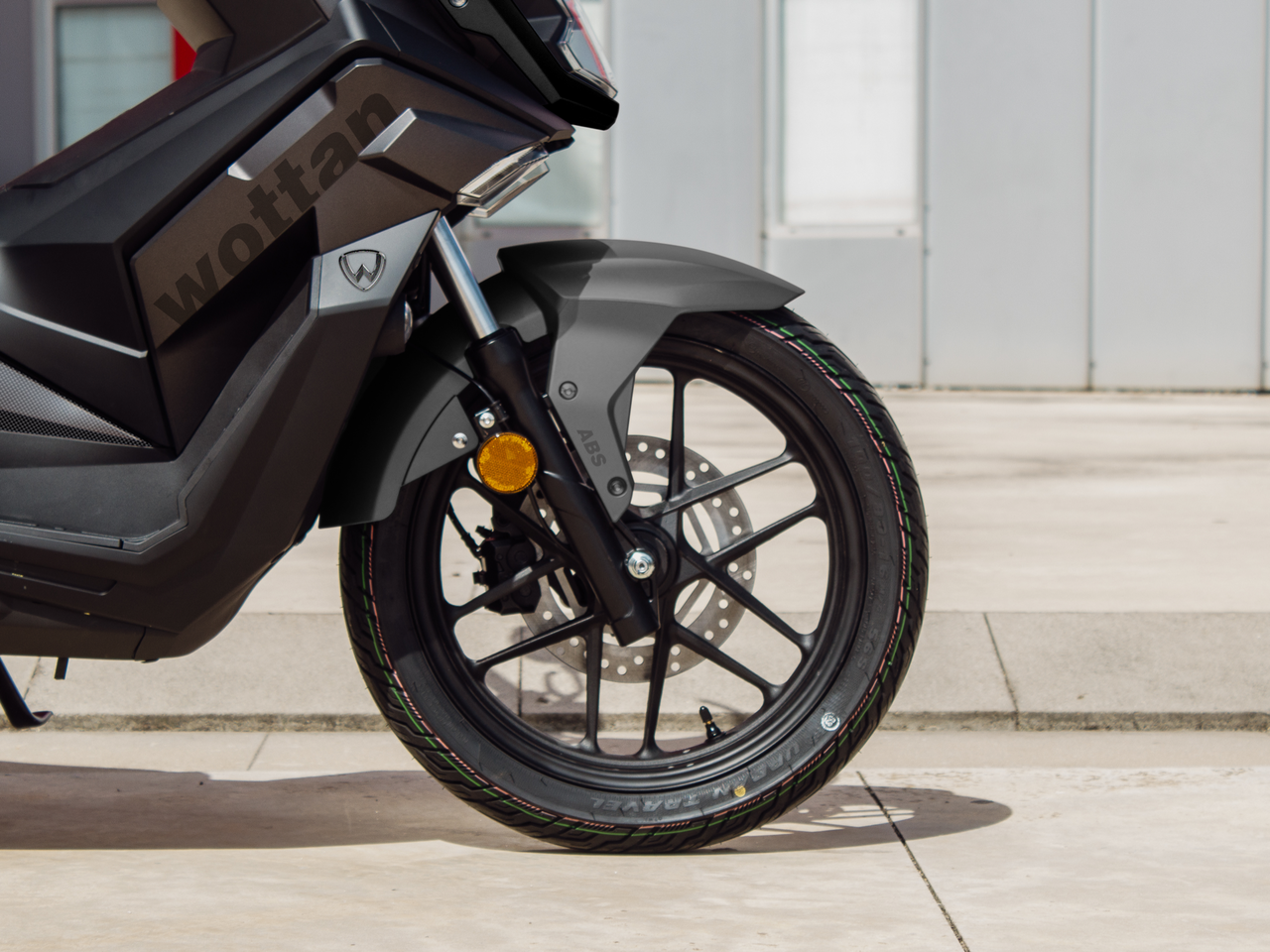 Detalle del scooter GT urbano Wottan Sixteen 125, destacando su rueda y diseño moderno.