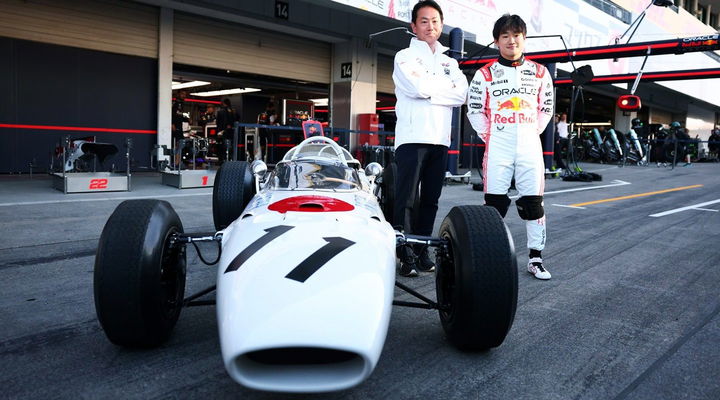 Yuki Tsunoda posando junto a un histórico monoplaza de Honda en el circuito.
