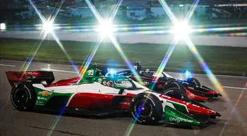 Dos coches de IndyCar en pista, resaltando sus atrevidos diseños de carrocería.