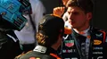 Max Verstappen discutiendo estrategias con su equipo mientras se prepara para la carrera.