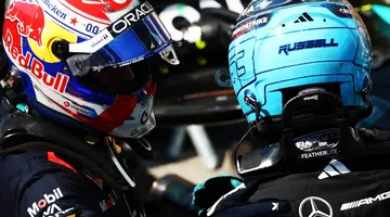 Max Verstappen discutiendo estrategias con George Russell, Mercedes, en pista.