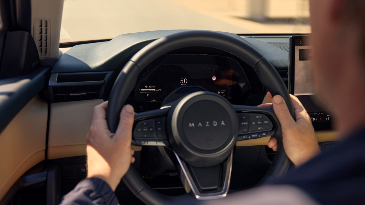 Interior del Mazda CX-5 2026, destacando el volante y el panel de instrumentos.