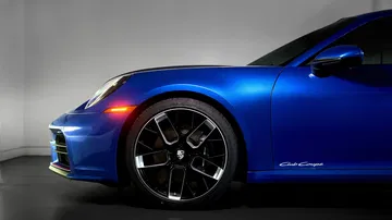 Vista lateral del Porsche 911 Club Coupe, destacando su diseño elegante y detalles exclusivos.