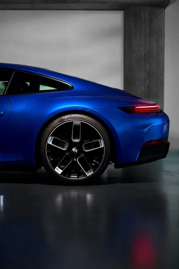 Vista lateral trasera del Porsche 911, destacando su elegante diseño y llantas.