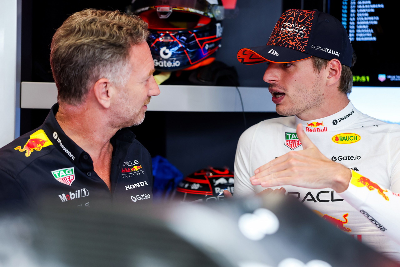 Christian Horner y Max Verstappen discuten estrategias en el garaje de Red Bull.