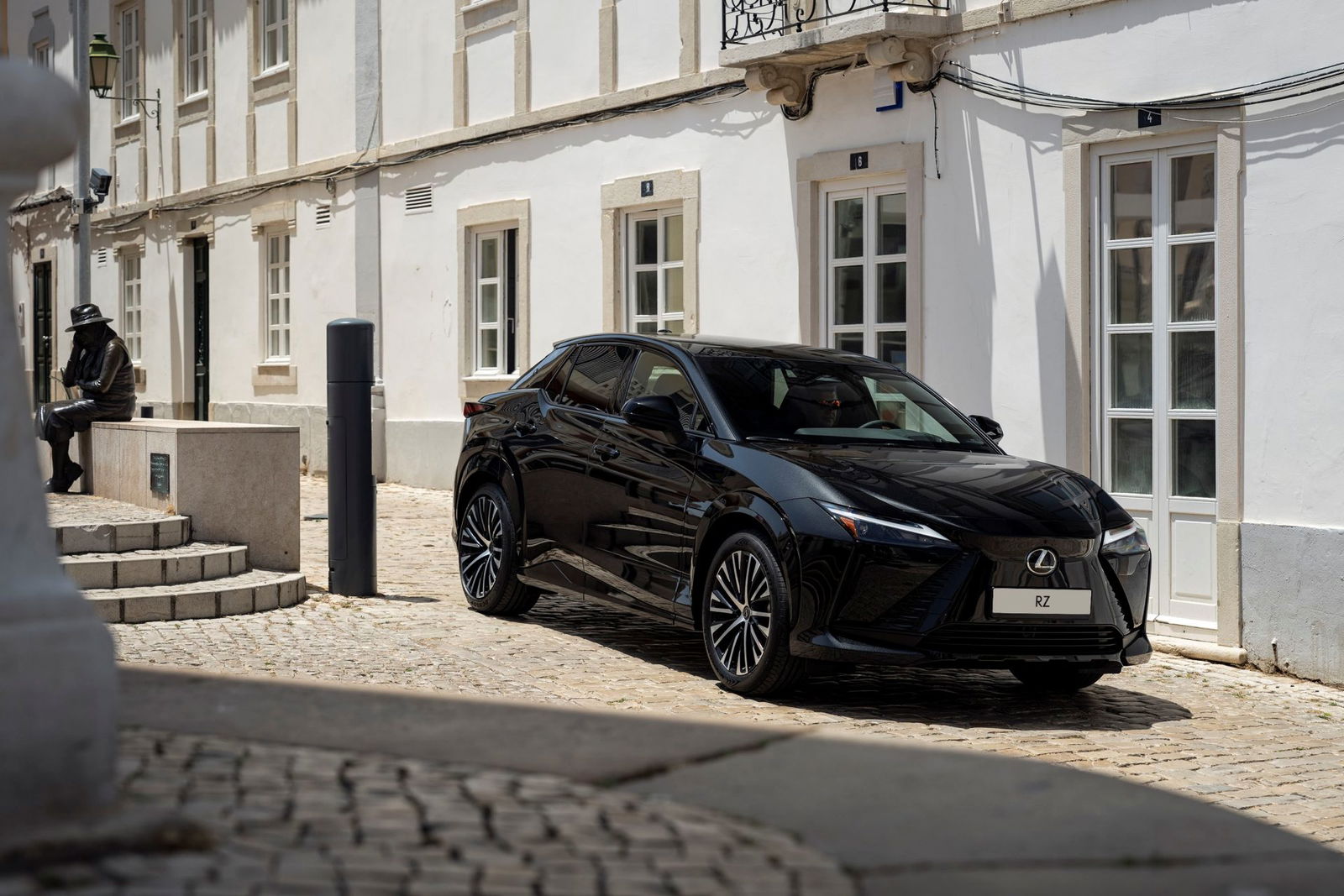 El Lexus RZ 2026, ahora más asequible, muestra su elegante diseño en un entorno urbano.