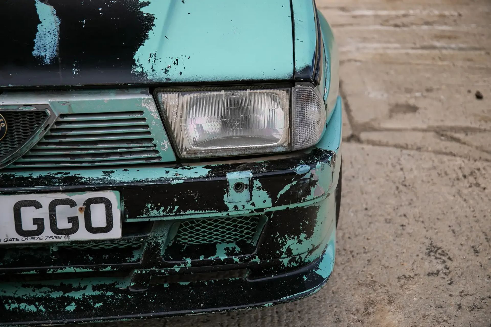 Vista frontal del Alfa Romeo 75, mostrando desgaste y carácter de coleccionista