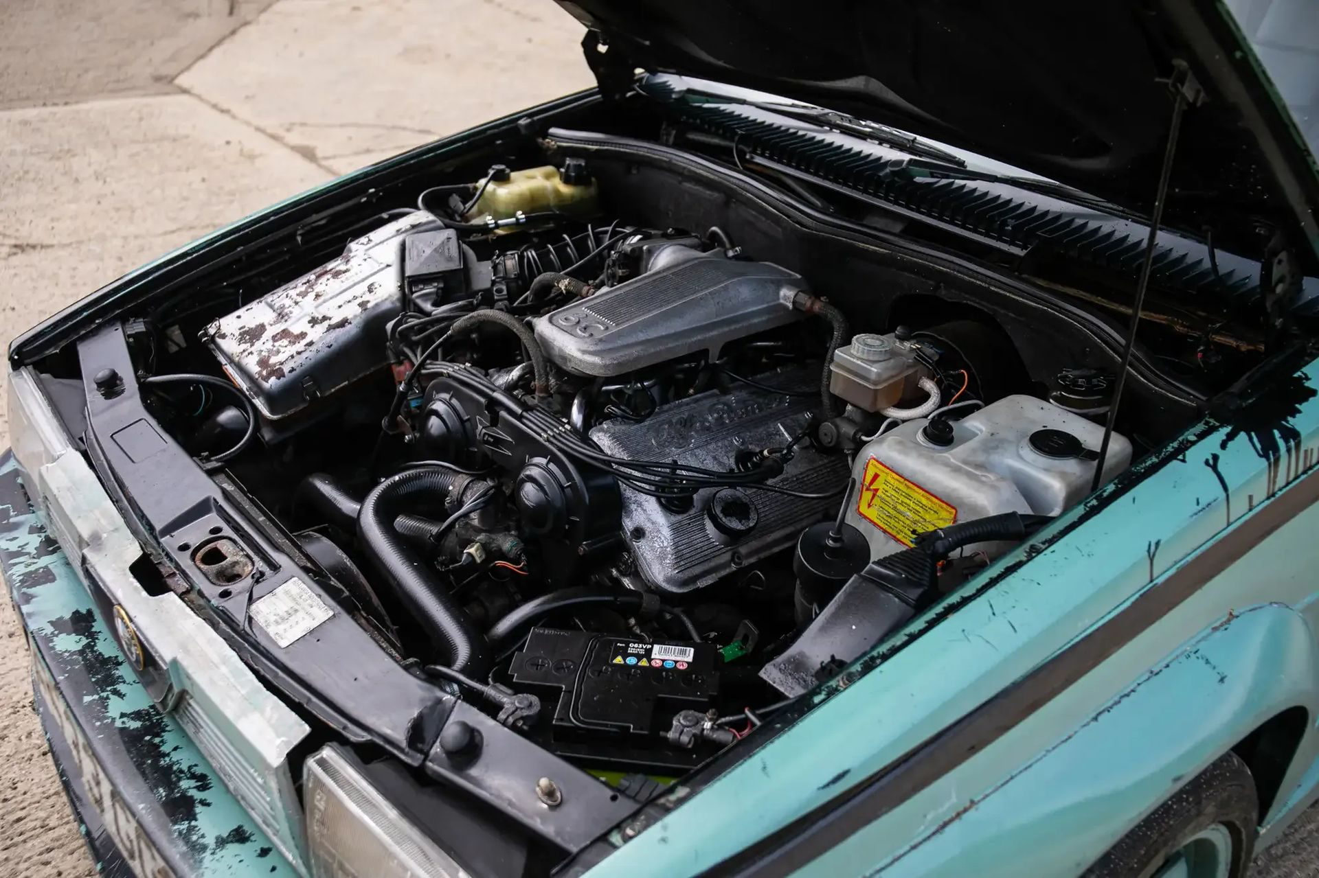 Vista del motor del Alfa Romeo 75, mostrando su estado de uso. Una joya con historia detrás.