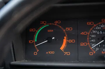 Detalle del cuadro de instrumentos del Alfa Romeo 75, mostrando los indicadores de velocidad y revoluciones.