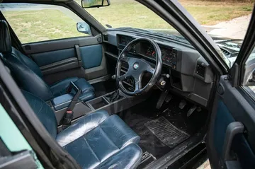 Interior del Alfa Romeo 75, con asientos de cuero y detalles deportivos. Interior del Alfa Romeo 75, con asientos de cuero y detalles deportivos.