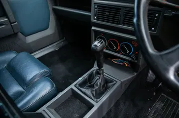 Cabina del Alfa Romeo 75, muestra un diseño clásico y asientos cómodos.