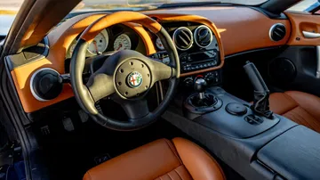 Vista del interior del Alfa Romeo TZ3 Stradale con detalles en cuero y tablero deportivo.