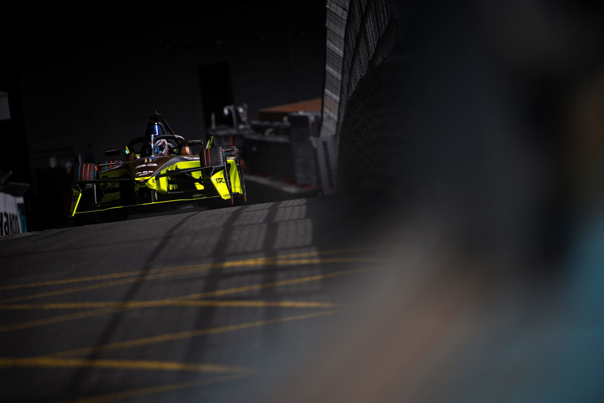 Coche de competición eléctrico en acción durante la carrera nocturna.