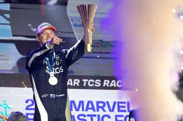 Celebración en la Fórmula E con el coche DMC tras una victoria impresionante.