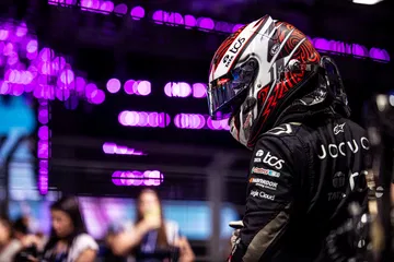 Piloto en boxes preparado para la competencia, reflejando la emoción del evento.