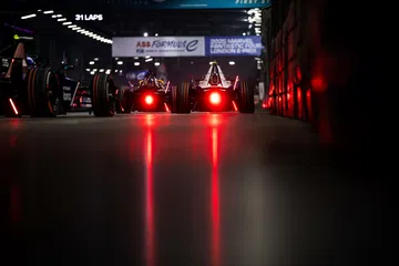 Dos monoplazas eléctricos listos para la carrera en Londres, con luces traseras iluminadas.