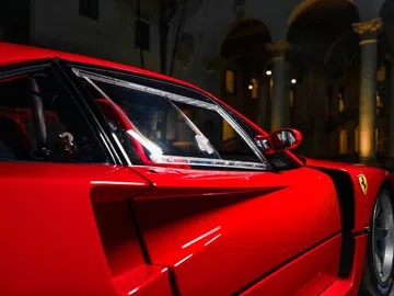 Vista lateral del Ferrari F40 LM, destacando su diseño aerodinámico y color rojo emblemático. Vista lateral del Ferrari F40 LM, destacando su diseño aerodinámico y color rojo emblemático.