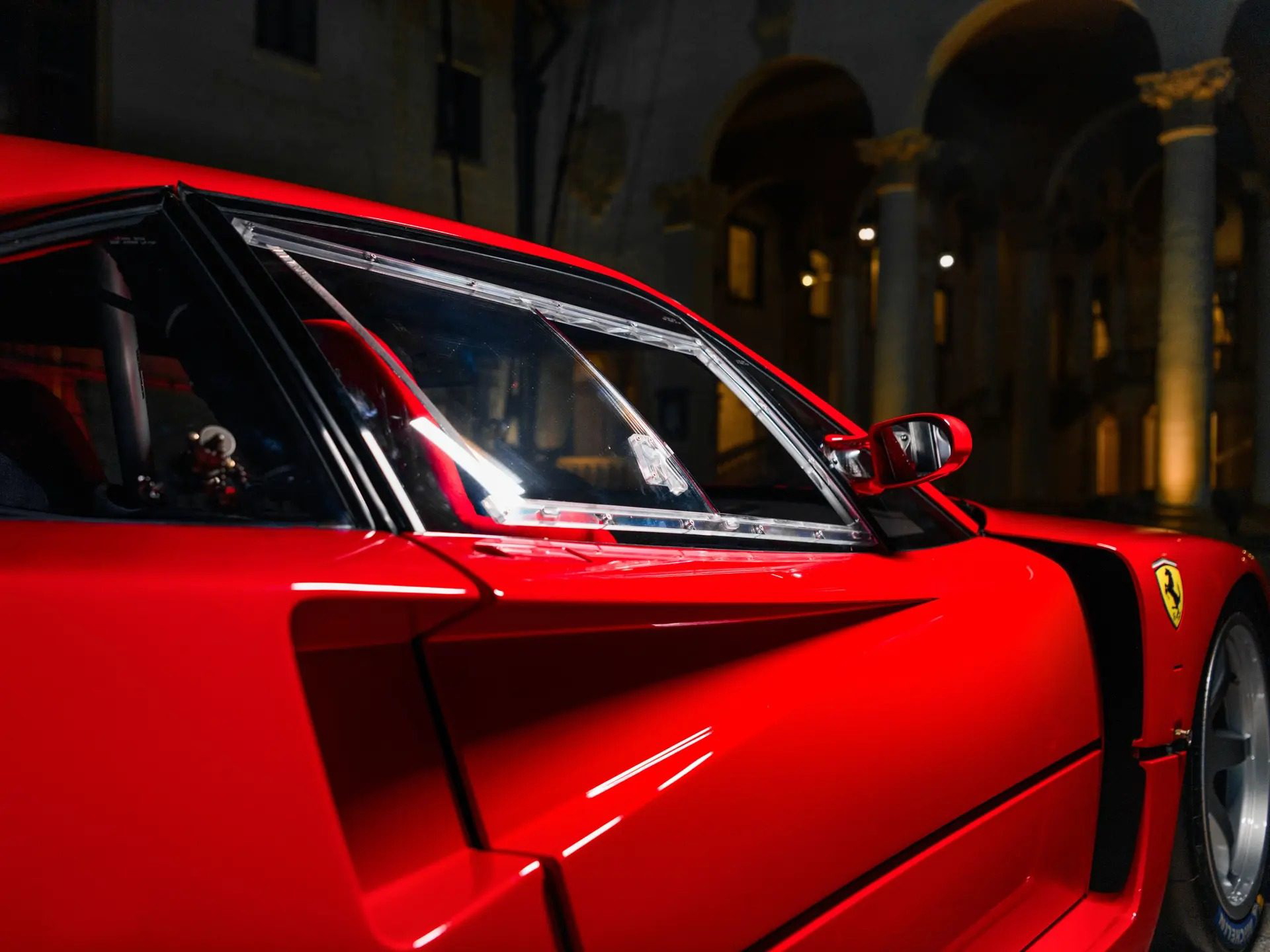 Vista lateral del Ferrari F40 LM, destacando su diseño aerodinámico y color rojo emblemático.