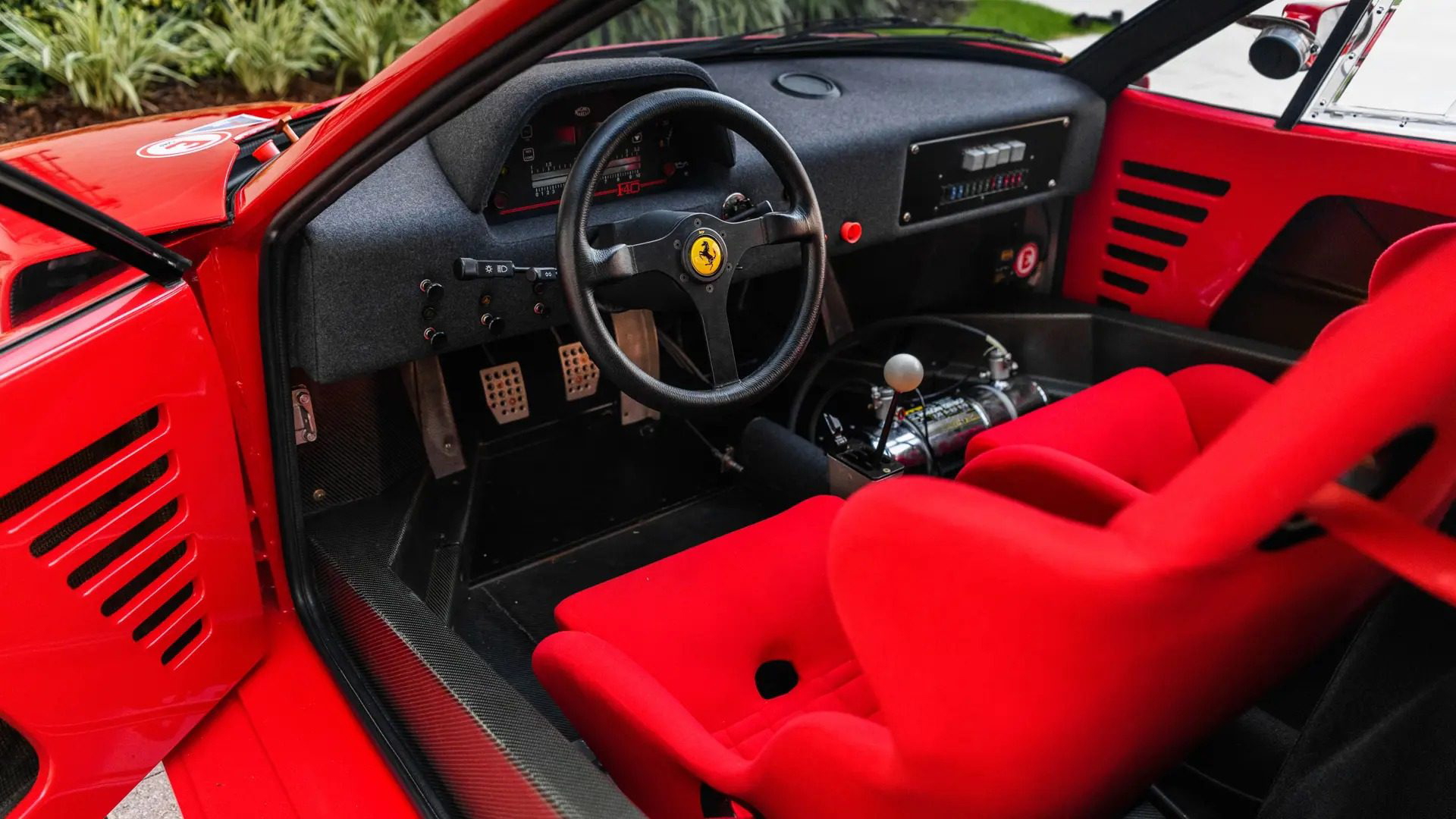 Cabina del Ferrari F40 LM con asientos rojos y acabados Racing.