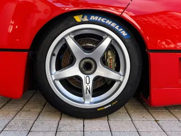 Rueda del Ferrari F40 LM, muestra detalles de la llanta y frenos, símbolo de su potencia.