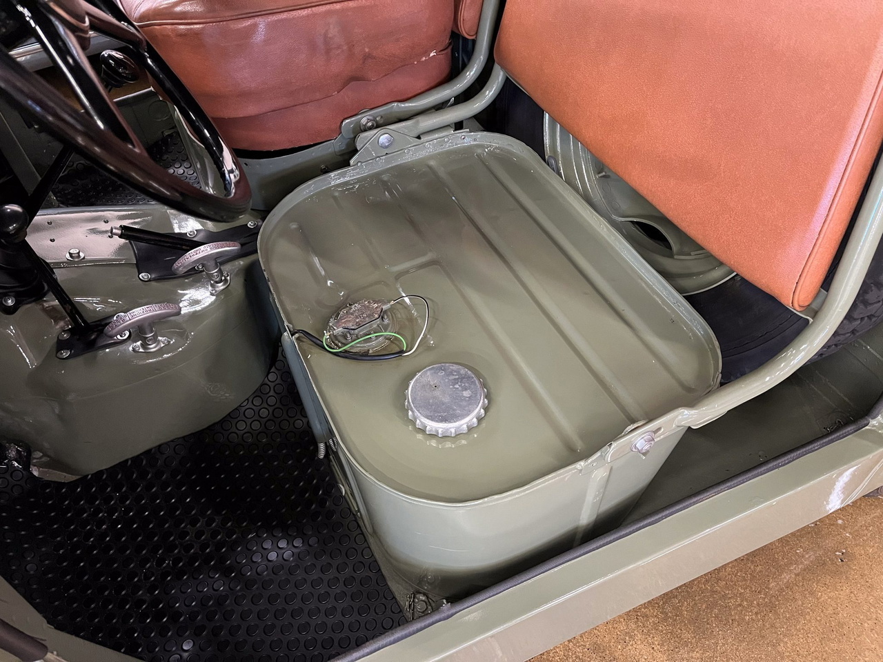 Vista del interior del Fiat Campagnola, con tanque de combustible visible y asientos de cuero.