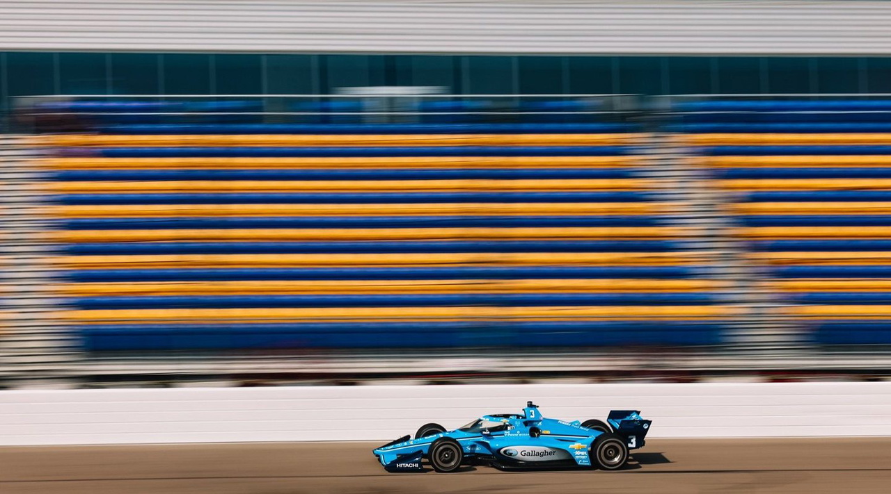Coche de IndyCar en acción en el Iowa Speedway, mostrando su diseño aerodinámico.
