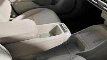 Detalle del diseño interior, con énfasis en los asientos y consola central.