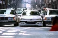 Mercedes y un taxi se enfrentan en un entorno urbano, mostrando contrastes de diseño.