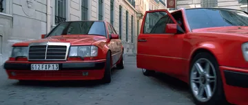 Escena icónica con dos coches rojos destacados, un Mercedes en primer plano.