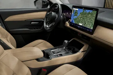 Vista del interior del Mazda CX-5 2026, con detalles en acabado claro y pantalla multimedia.