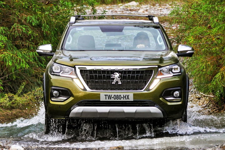 Peugeot Landtrek atravesando un tramo de agua, mostrando su capacidad todoterreno.