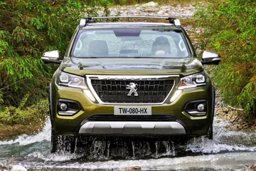 Peugeot Landtrek atravesando un tramo de agua, mostrando su capacidad todoterreno.