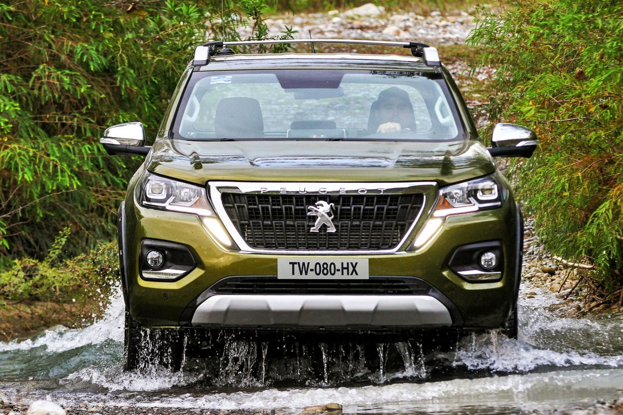 Peugeot Landtrek atravesando un tramo de agua, mostrando su capacidad todoterreno.