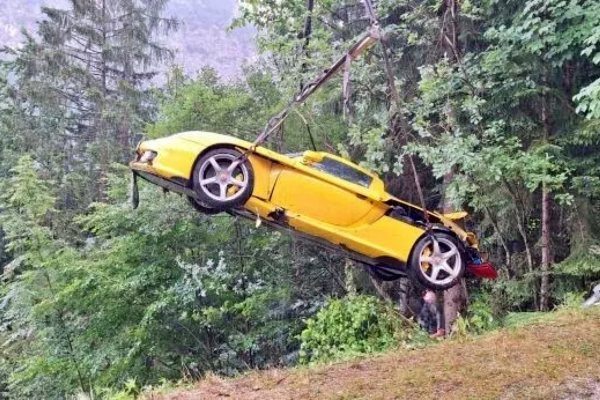 Porsche Carrera GT accidentado en Austria, colgando de una grúa.