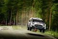 Un Ford compitiendo en el Rally de Finlandia 2025, saltando en un tramo forestal.