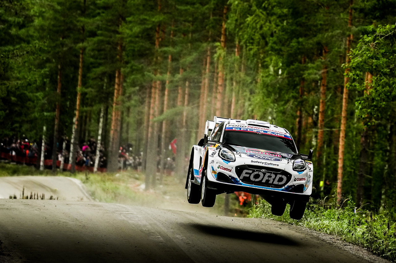 Un Ford compitiendo en el Rally de Finlandia 2025, saltando en un tramo forestal.