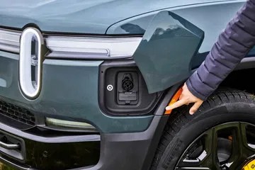 Detalle del puerto de carga del Rivian R1S, ideal para aventuras todoterreno.