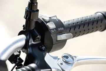 Vista del puño del manillar con controles, diseño moderno y ergonómico.