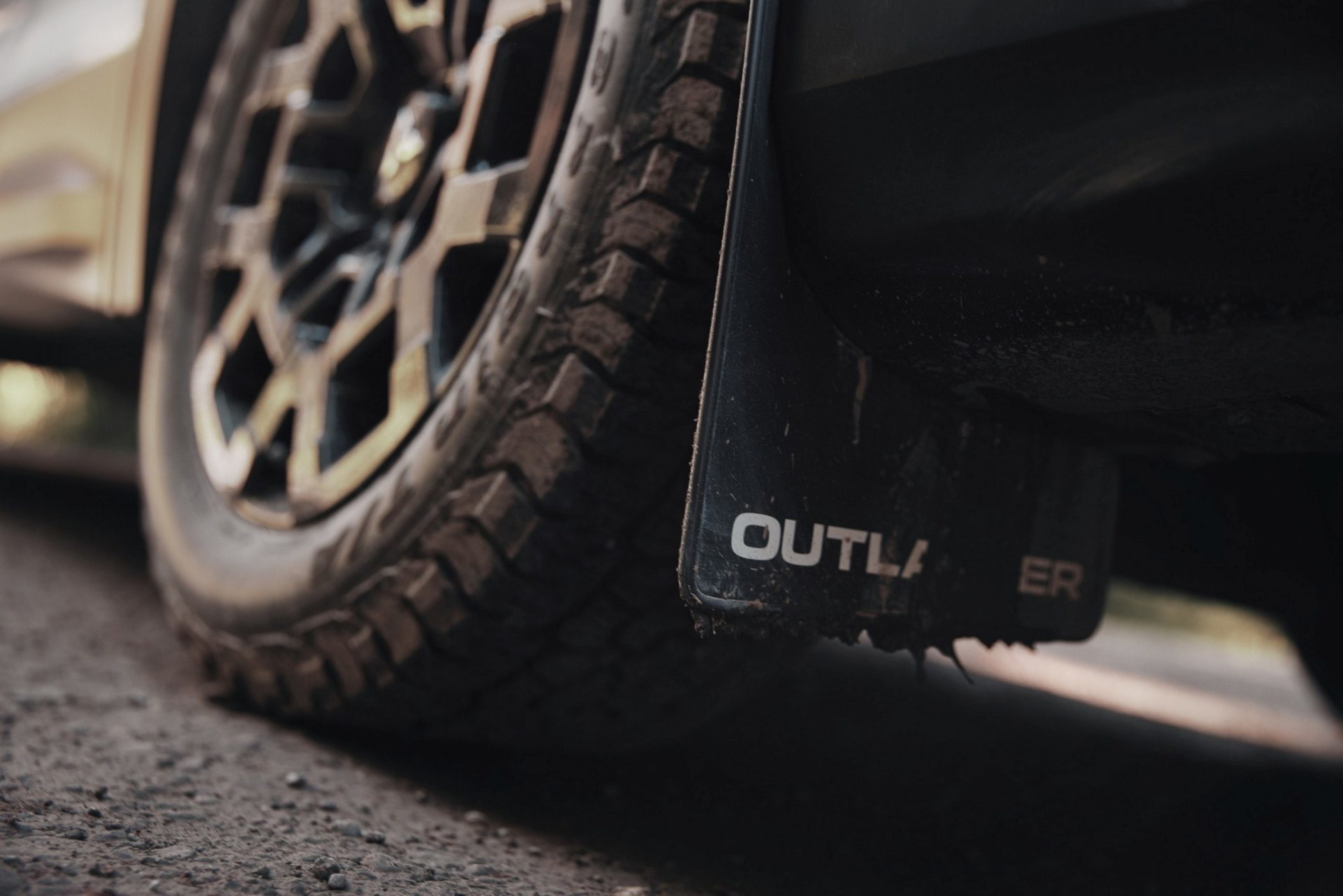 Vista lateral y trasera del Mitsubishi Outlander Trail Edition con enfoque en detalles de neumáticos